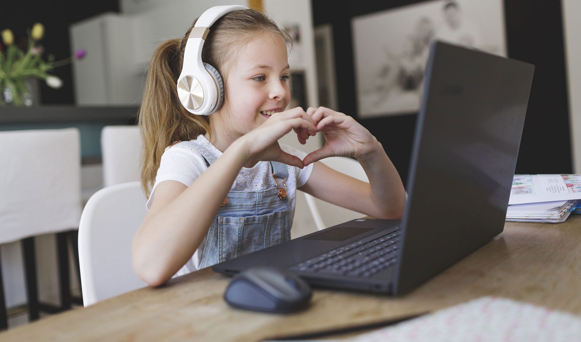 young girl wearing headphones attending online school